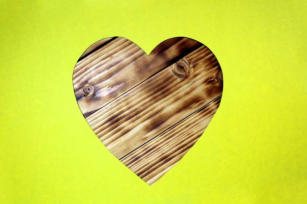 Serce Wycięte Żółtej Tektury Ułożone Drewnianym Tle — Zdjęcie stockowe