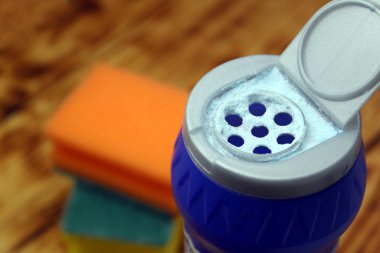 Çamaşır süngerinin arka planındaki mutfak temizleyicisi.