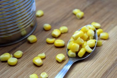 Jar of canned corn with a spoon on the table