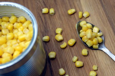 Jar of canned corn with a spoon on the table