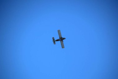 Mavi gökyüzünde yeşil küçük uçak uçar