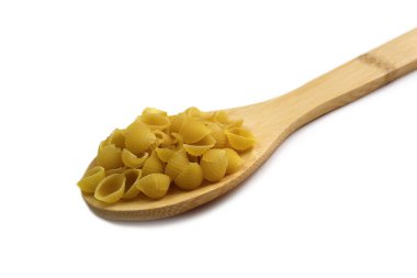 Beyaz arka planda tahta kaşıkta kabuklu makarna.