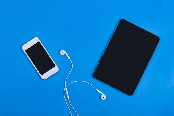 White phone with black tablet on a blue background — Stock Photo, Image