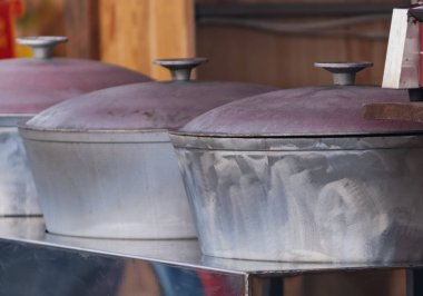 Kazıkta yemek pişirmek için büyük dökme tencereler.