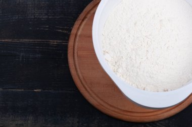 Ahşap bir masada hafif bir kasede un.