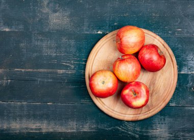 Yuvarlak bir ahşap stantta bir sürü kırmızı elma