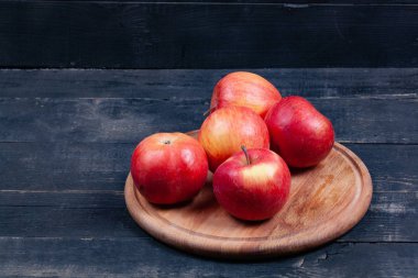 Yuvarlak bir ahşap stantta bir sürü kırmızı elma