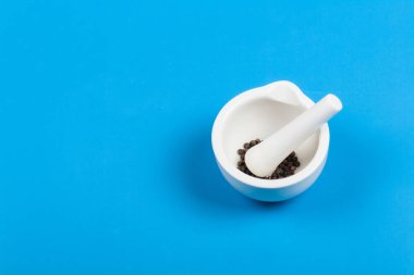 Mavi arka planda biber öğütmek için beyaz tabaklar