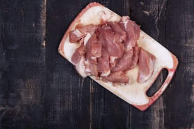 Koyu ahşap bir masada taze doğranmış et.