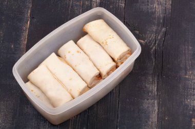 Ahşap bir masada plastik bir kasede bir sürü pişmiş krep.