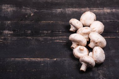  Koyu ahşap arka planda bir sürü mantar.