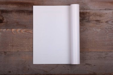 Ahşap zemin üzerinde boş çarşaflar olan dergi.