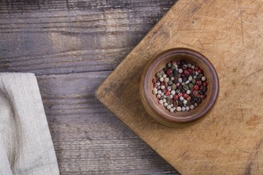 Tahta bir masada, koyu ahşap bir kasede baharatlı kırmızı biber.