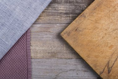 Ahşap bir masanın üstünde yemek kesmek için eski püskü bir mutfak tahtası.