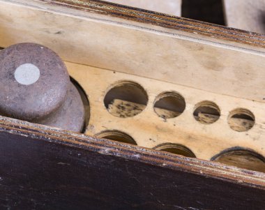 Eski tip demir ağırlıklar, ahşap arka plandaki malları tartmak için.