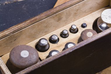 Eski tip demir ağırlıklar, ahşap arka plandaki malları tartmak için.