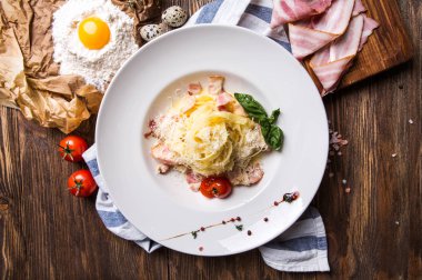 İtalyan makarna carbonara pastırma ve sarısı üzerinde beyaz bir plaka ile 