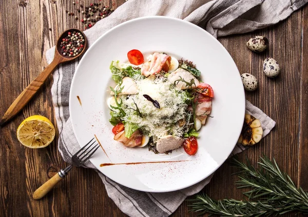 Karanlık bir woo pastırma ve Bıldırcın yumurta beyaz tabakta Sezar salatası