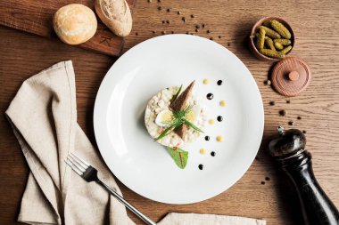 Restoran ve modern ahşap bir masa üzerinde iki çavdar croutons olivier salata salatası