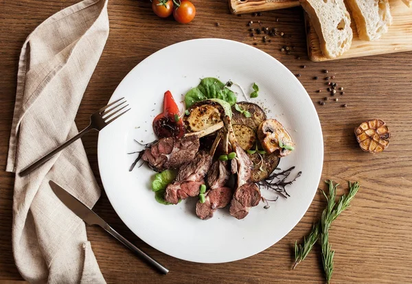 Ahşap bir masa üzerinde ızgara sebzeli ızgara kaburga