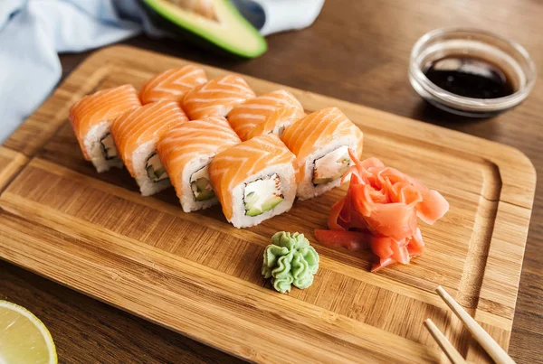 日本寿司卷与芥末 姜酱油和筷子和一杯酒在木制板上 — 图库照片