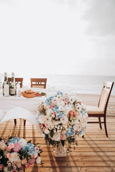 美丽的婚礼桌设置和婚礼装饰与餐具在日落和海背景 — 图库照片
