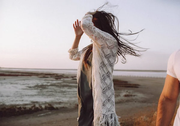 Menina com cabelos longos e escuros voando no vento ao pôr do sol com beaut — Fotografia de Stock