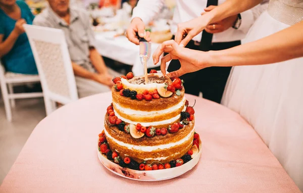 Wedding beautiful naked cake with open cakes and cream, with ber