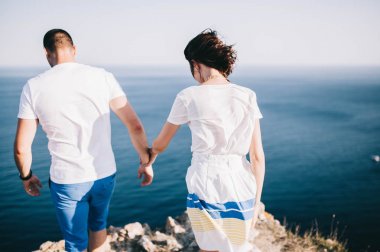 dağlar ve deniz güzel manzaralı bir kaya üzerinde yürüyen genç sevgi dolu Çift