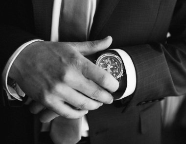 Düğün veya şık adam işadamı bir saat elinde getirmeden önce sabah damat