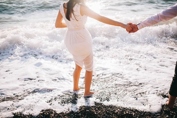 結婚式のカップル 夕暮れ時のビーチに沿って実行している新婚夫婦 — ストック写真