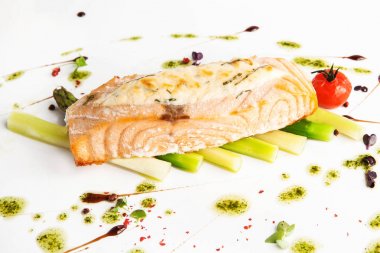 domates ve beyaz zemin üzerine pesto sos ile kuşkonmaz pişmiş somon biftek