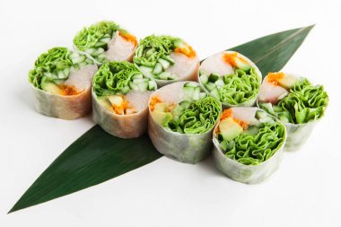 parlak balık, havyar ve bir bambu yaprak yeşillik ile beyaz bir arka plan üzerinde Çin böreği