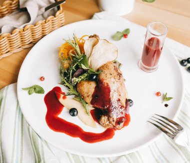 ördek confit polenta üzerinde ahşap bir masa üzerinde yaban mersini-bal soslu bacak