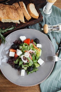 Ahşap bir masa ekmek ile servis taze Yunan salatası