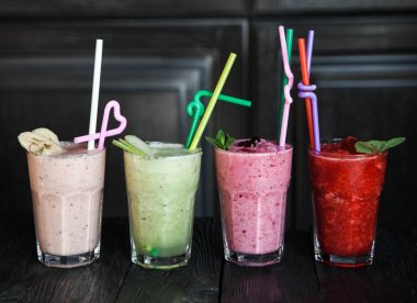 smoothies ahşap koyu arka plan üzerinde dört farklı