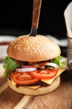 Burger buğday ekmek, patates kızartması ve salata ahşap oyun tahtası