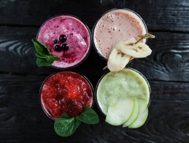 smoothies bir ahşap koyu arka plan üzerine dört farklı göster