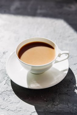 Beyaz fincan süt ile black tea ya da bir daire gri beton zemin üzerine sütlü kahve