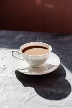 Beyaz fincan süt ile black tea ya da bir daire gri beton zemin üzerine sütlü kahve