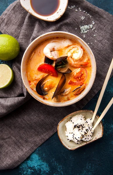 Japanese tom-yam soup with seafood and rice, chopsticks and lime