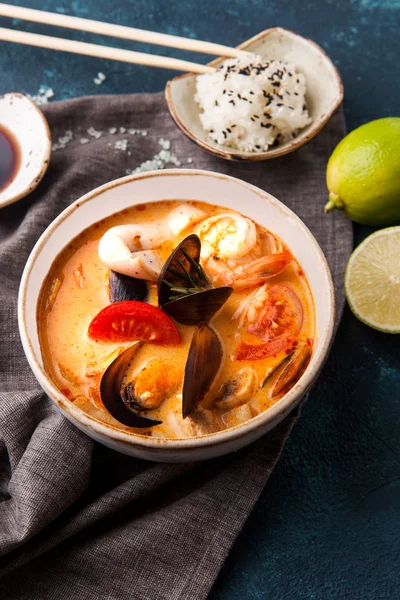 Japanese tom-yam soup with seafood and rice, chopsticks and lime