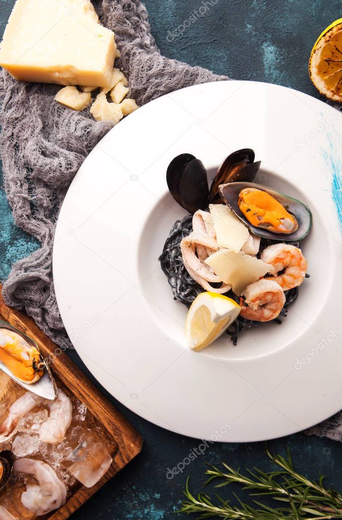 beautiful serving of black pasta with cuttlefish ink and seafood, shrimp, mussels, squid