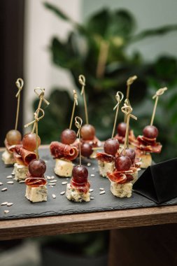 Atıştırmalıklar, amusebouche, aperatifler, parmak yiyecekleri - mavi Cheeze, jamon, üzüm 