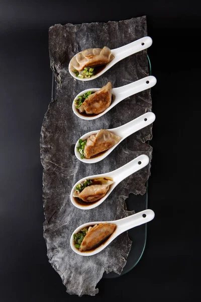 Pangsit gedza Jepang goreng dalam sendok dengan latar belakang gelap — Stok Foto