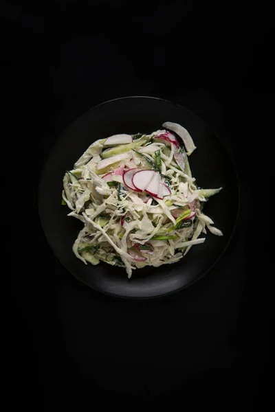 Σαλάτα λάχανο, ραπανάκι και αγγούρι με ξινή κρέμα σε μαύρο φόντο Royalty Free Εικόνες Αρχείου
