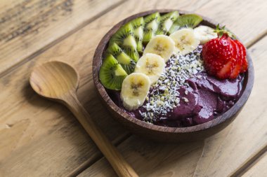 Renkli meyve ve tahta kaşık ile acai kase
