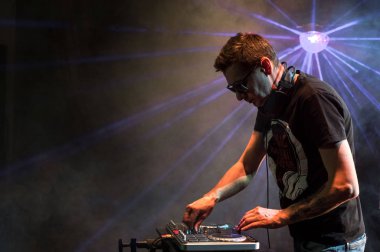 Bir gece kulübünde DJ iş. Club disko ışığı. DJ pikap arkasında.