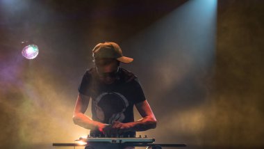 Bir gece kulübünde DJ iş. Club disko ışığı. DJ pikap arkasında.