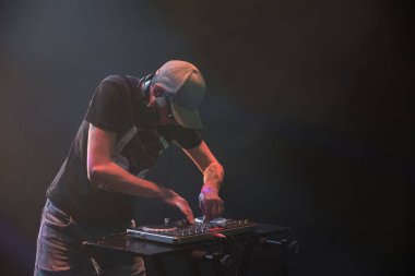 Bir gece kulübünde DJ iş. Club disko ışığı. DJ pikap arkasında.